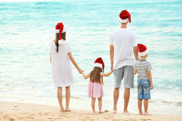 Casal jovem com crianças na praia. Conceito de Natal — Fotografia de Stock