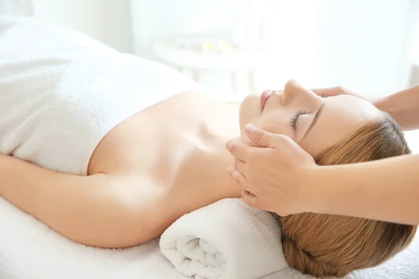 Mujer joven disfrutando del masaje facial en el salón de spa — Foto de Stock