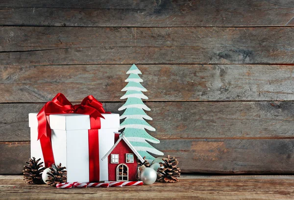 Dárková krabice a vánoční ozdoby na dřevěném stole — Stock fotografie