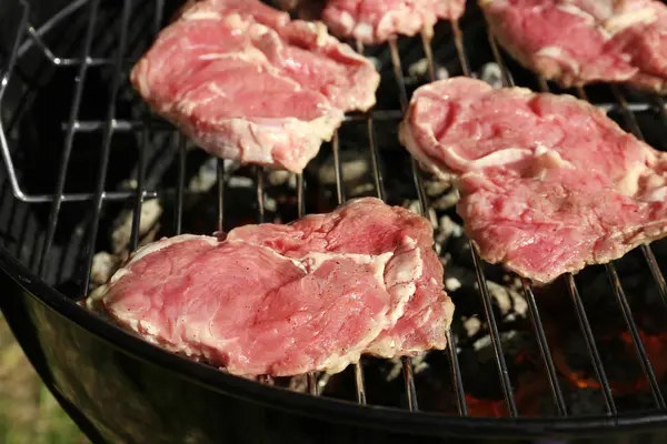 Raw steaks on gril — Stock Photo, Image