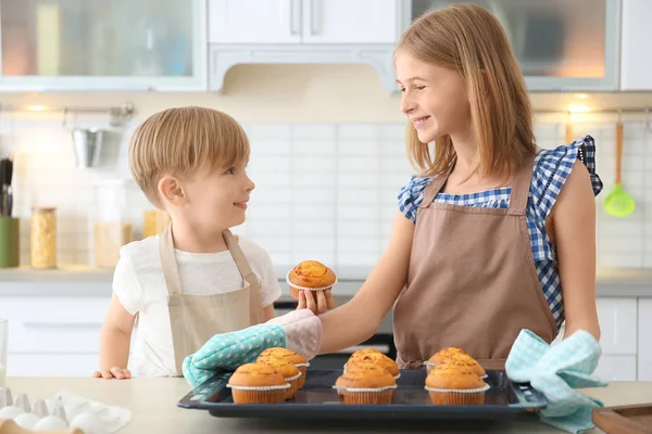 少年とキッチンでマフィンを持つ少女。料理クラスの概念 — ストック写真