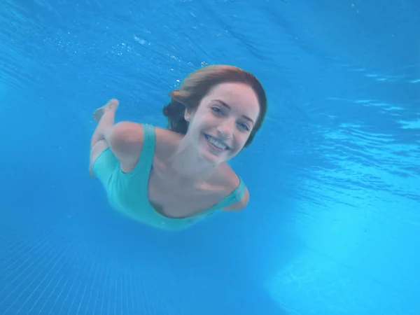 Jonge vrouw onder water zwemmen — Stockfoto