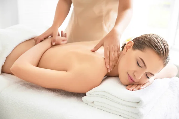 Junge schöne Frau mit Massage im Wellness-Salon — Stockfoto