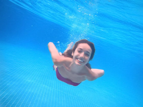 Jonge vrouw onder water zwemmen — Stockfoto