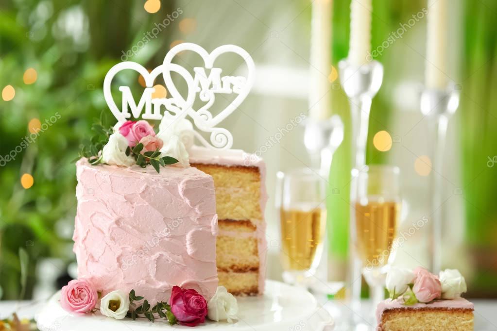 Sliced lesbian wedding cake on blurred background