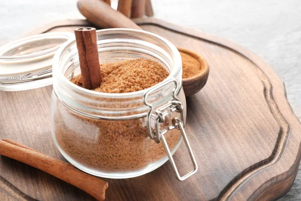 Kaneel suiker in glazen pot op houten bord — Stockfoto