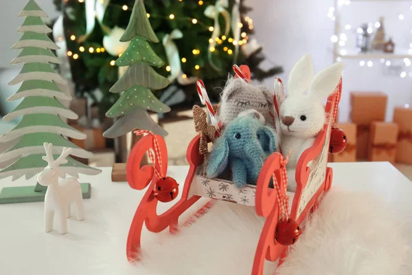 Sledge com brinquedos bonitos para bebê na mesa no quarto decorado para o Natal — Fotografia de Stock