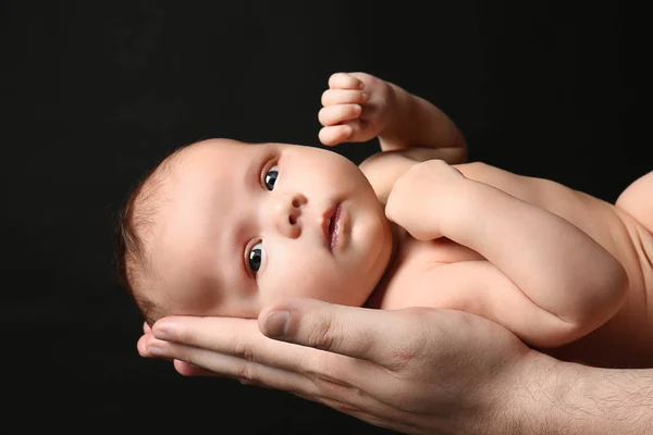 Otec držel novorozence na černém pozadí — Stock fotografie