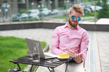 Masada açık havada çalışan dizüstü bilgisayar ile genç blogger