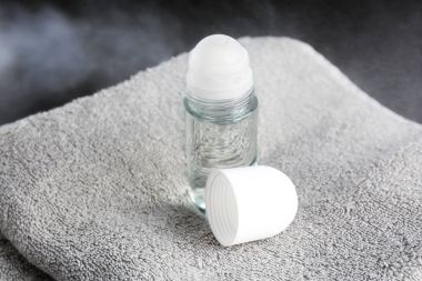 Koyu arka plan üzerinde havlu ile deodorant