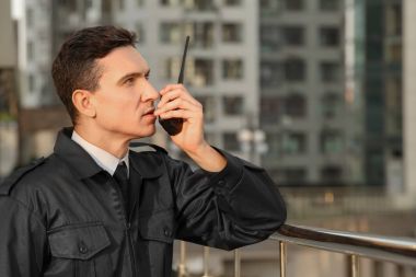 Erkek güvenlik görevlisi ile taşınabilir radyo, açık havada