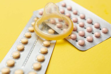 Doğum kontrol hapları ve prezervatif renk arka plan üzerinde