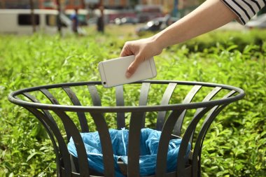Genç kadın Smartphone açık havada Çöp Kutusu'na atma