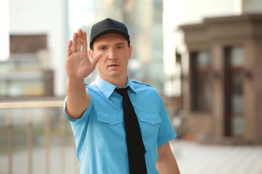 Erkek güvenlik görevlisi dur jest, açık havada gösterilen