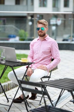 Masada açık havada çalışan dizüstü bilgisayar ile genç blogger