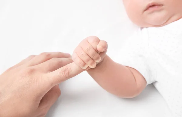 白い背景の上のかわいい小さな赤ちゃん持株母の指 — ストック写真