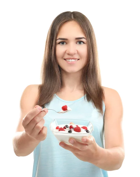 Mujer joven comiendo yogur sobre fondo blanco — Foto de Stock