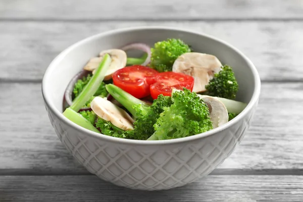 Tigela com salada de brócolis na mesa — Fotografia de Stock