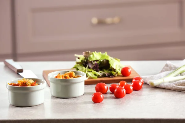 Ramekins con cena y tomates en la mesa en la cocina — Foto de Stock
