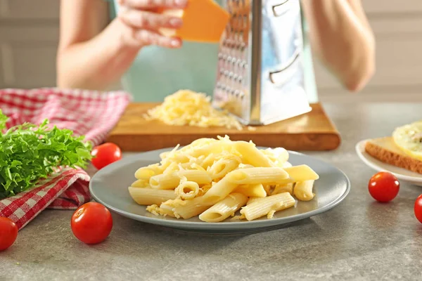 Woman preparing tasty dinner on table in kitchen