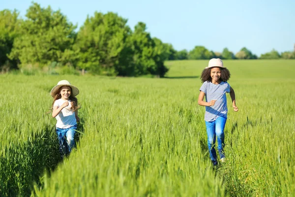 Glückliche kleine Mädchen im grünen Feld — Stockfoto