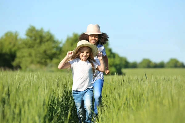 Glückliche kleine Mädchen im grünen Feld — Stockfoto