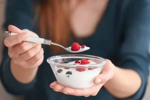 Young woman eating yogurt, closeup — Stock Photo, Image