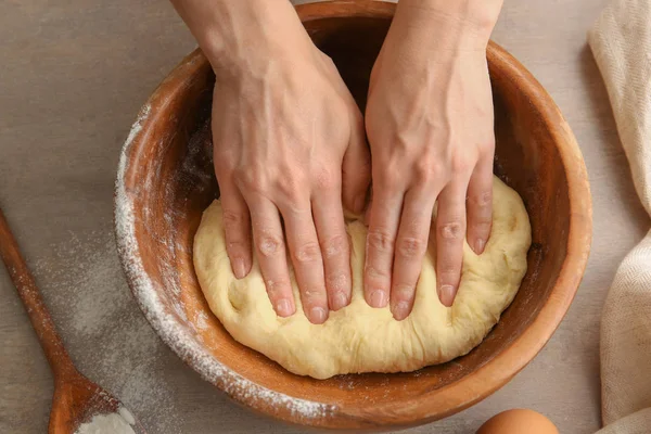 Kvinnlig kock knåda deg i skål på köksbordet — Stockfoto