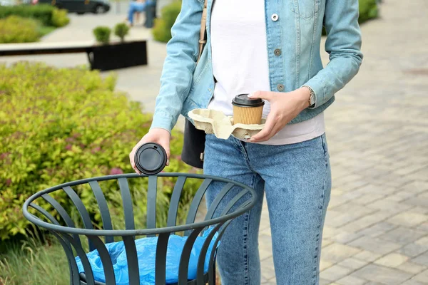 Young woman throwing paper cup