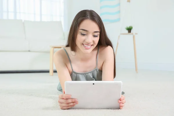 Jeune femme cherchant des informations à l'aide de tablette à la maison — Photo