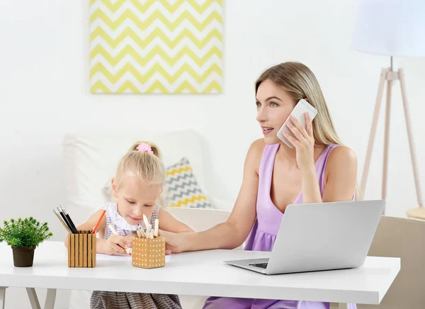 Jeune femme occupée avec sa fille — Photo