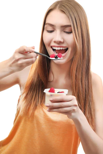 Mujer joven comiendo yogur sobre fondo blanco — Foto de Stock