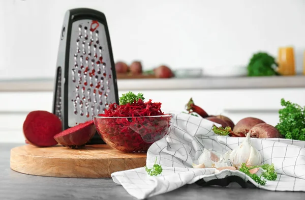 Fresh beetroot and grater on table in kitchen — Stock Photo, Image