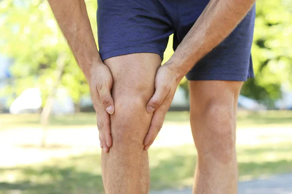 Jeune homme souffrant de douleur à la jambe — Photo