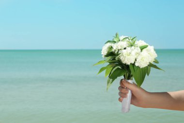 Güzel buket mavi deniz arka planda tutan kadın. Beach düğün kavramı