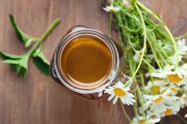 Ahşap zemin üzerine çiçekli papatya çayı Mason kavanoz