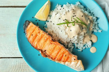 Plaka dilim somon, pirinç ve lezzetli bir sos ile 