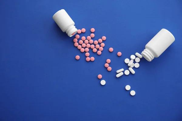 Plastic containers with pills on color background — Stock Photo, Image