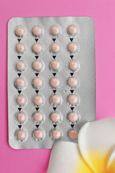 Blister di pillole contraccettive con fiore su sfondo di colore — Foto Stock