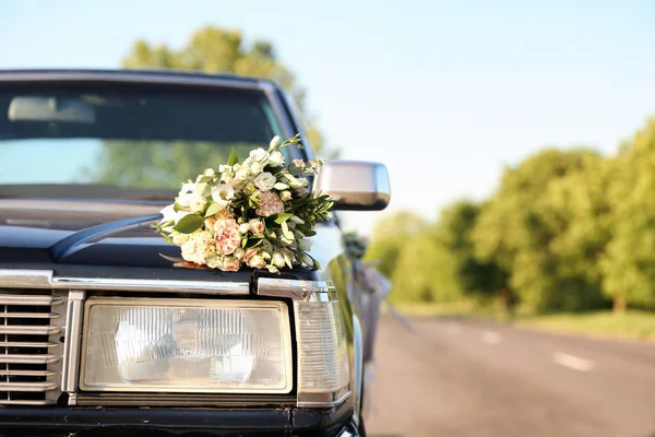 Hermosa decoración floral en el coche de boda al aire libre — Foto de Stock