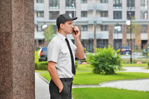 Male security guard with portable radio, outdoors — Stock Photo, Image