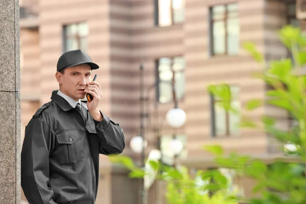 Male security guard with portable radio, outdoors — Stock Photo, Image