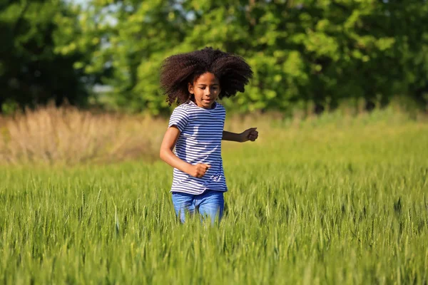 Niña afroamericana en el campo verde — Foto de Stock