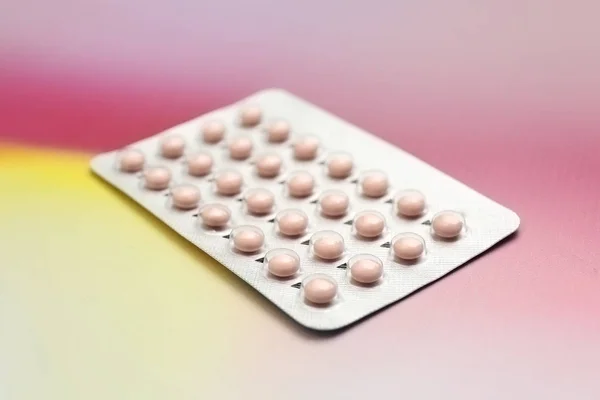 Блістер з контрацептивними таблетками на кольоровому фоні — стокове фото