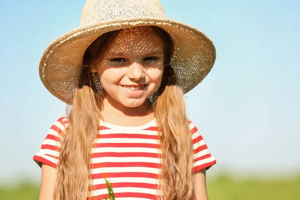 Lycklig liten flicka i grönt fält och sky på bakgrund — Stockfoto