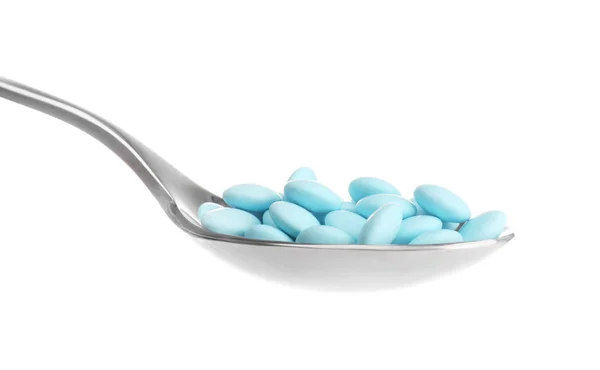 Cucchiaio con pillole colorate su sfondo bianco — Foto Stock
