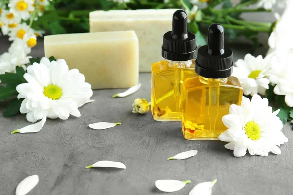 Uçucu yağ, sabun ve papatya çiçeği ile şişe