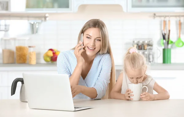 Occupato giovane donna con sua figlia a casa — Foto Stock