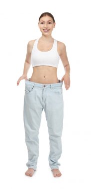 Beyaz arka plan üzerinde büyük boy kot pantolon güzel ve genç birbayan. Diyet kavramı