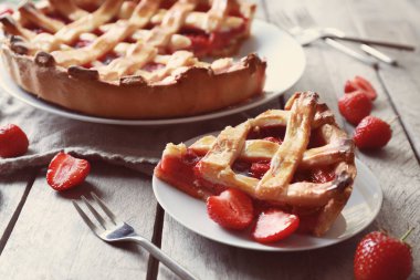 Lezzetli bir parça ahşap masa üzerinde çilekli kek ile plaka